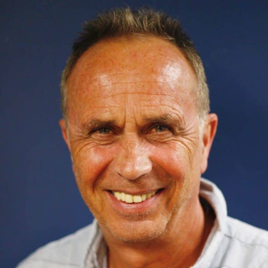 Dr Ulrich Schall, Senior Consultant Child & Adolescent Psychiatrist at Educare Specialist Services, wearing a light collared shirt against a solid dark blue background.